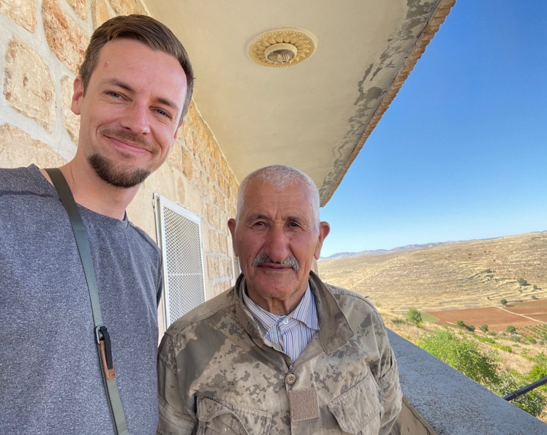 Ruben Vermeer beside the elderly Assyrian custodian of the church of Inwardo, on a stone balcony above terraced hills in Tur Abdin, Turkey