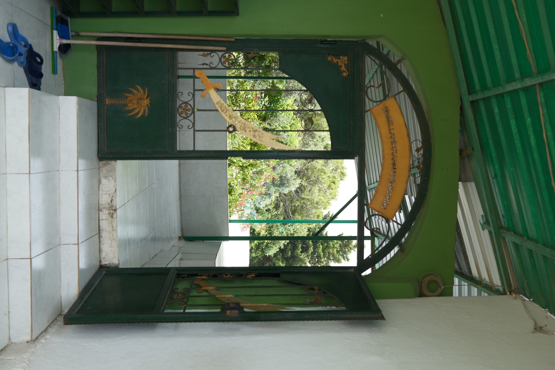The green wrought-iron gate of an Alawite shrine near Samandağ, decorated with a gilded Zulfiqar sword