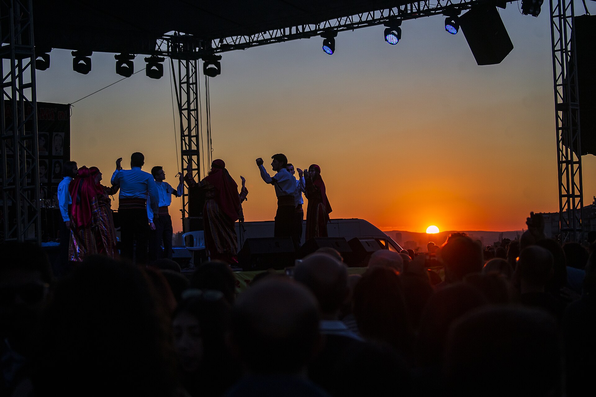 Semah dancers silhouetted against a sunset at an Alevi festival stage