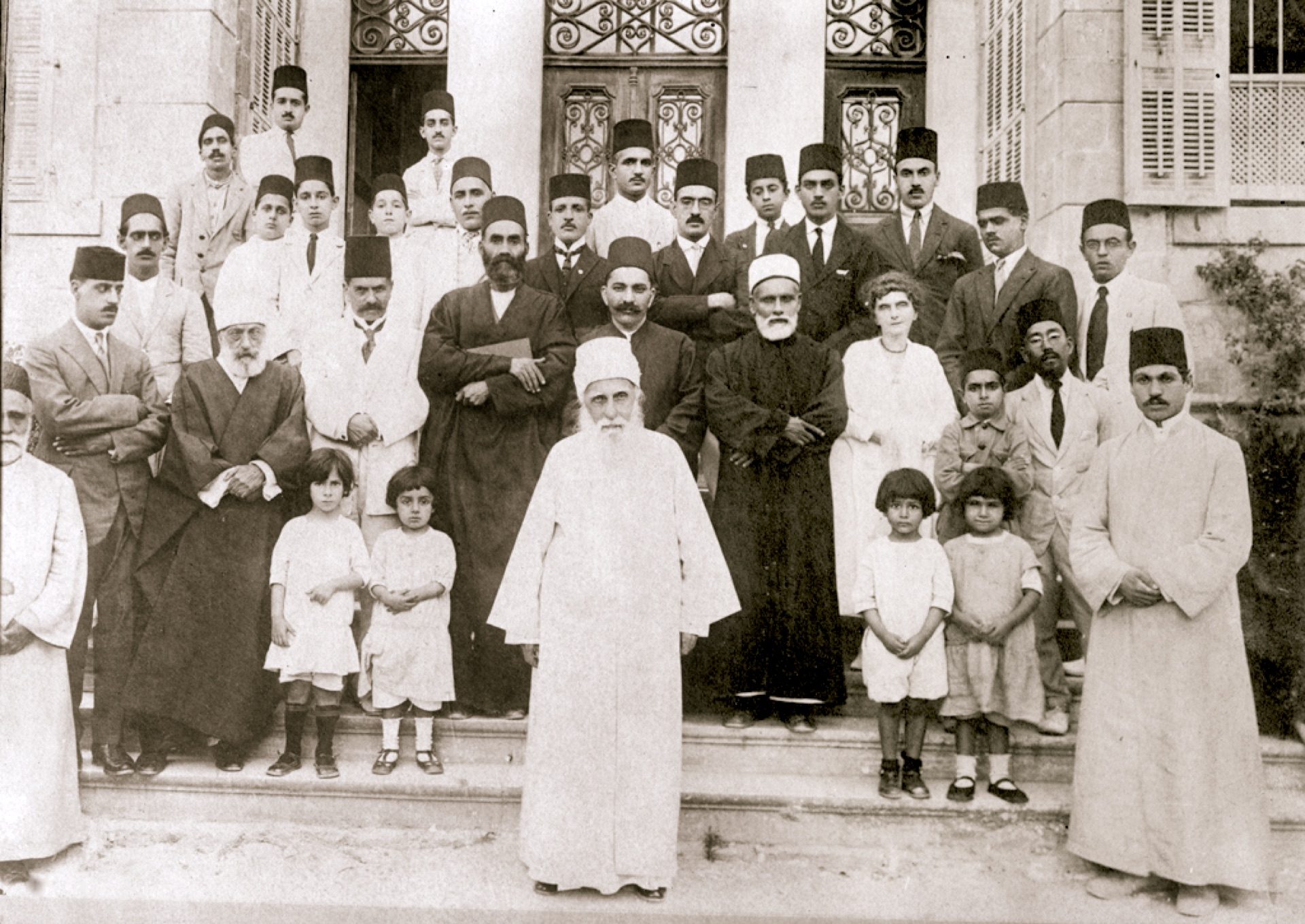 Abdu'l-Bahá seated with his grandsons and companions, historic photograph