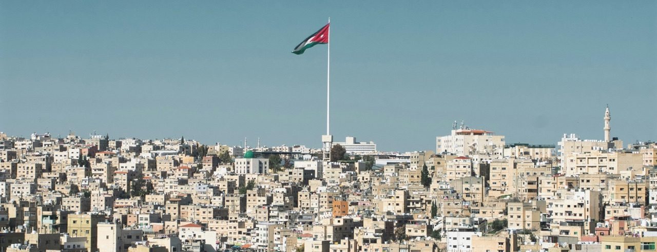 The skyline of modern Amman at dusk, hills covered in pale stone buildings