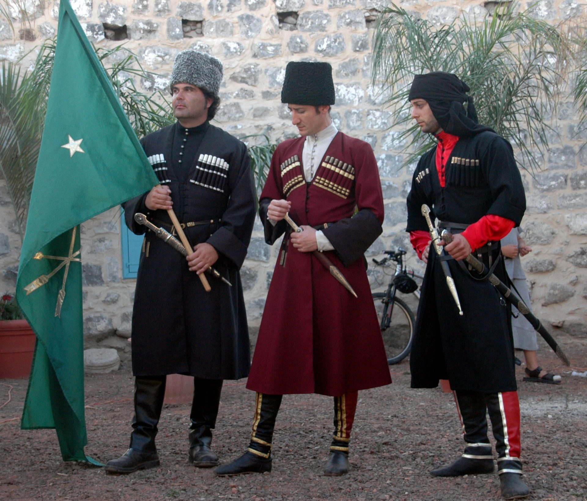 Circassian men in black cherkeska coats with silver cartridge holders at a community celebration