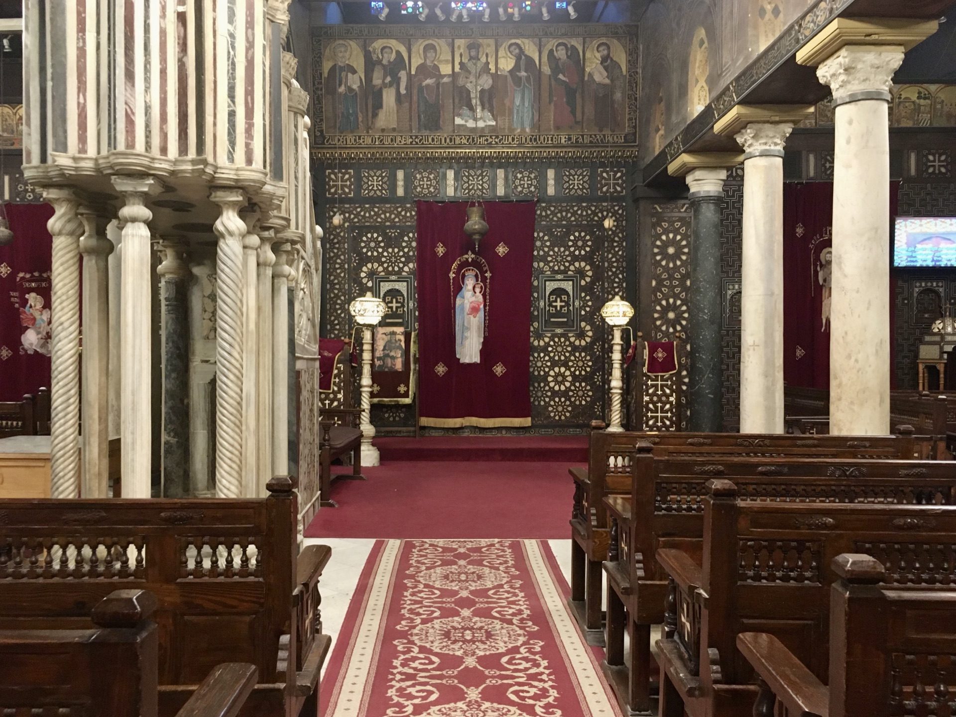 The nave of the Hanging Church in Old Cairo with its inlaid pulpit and lamplight
