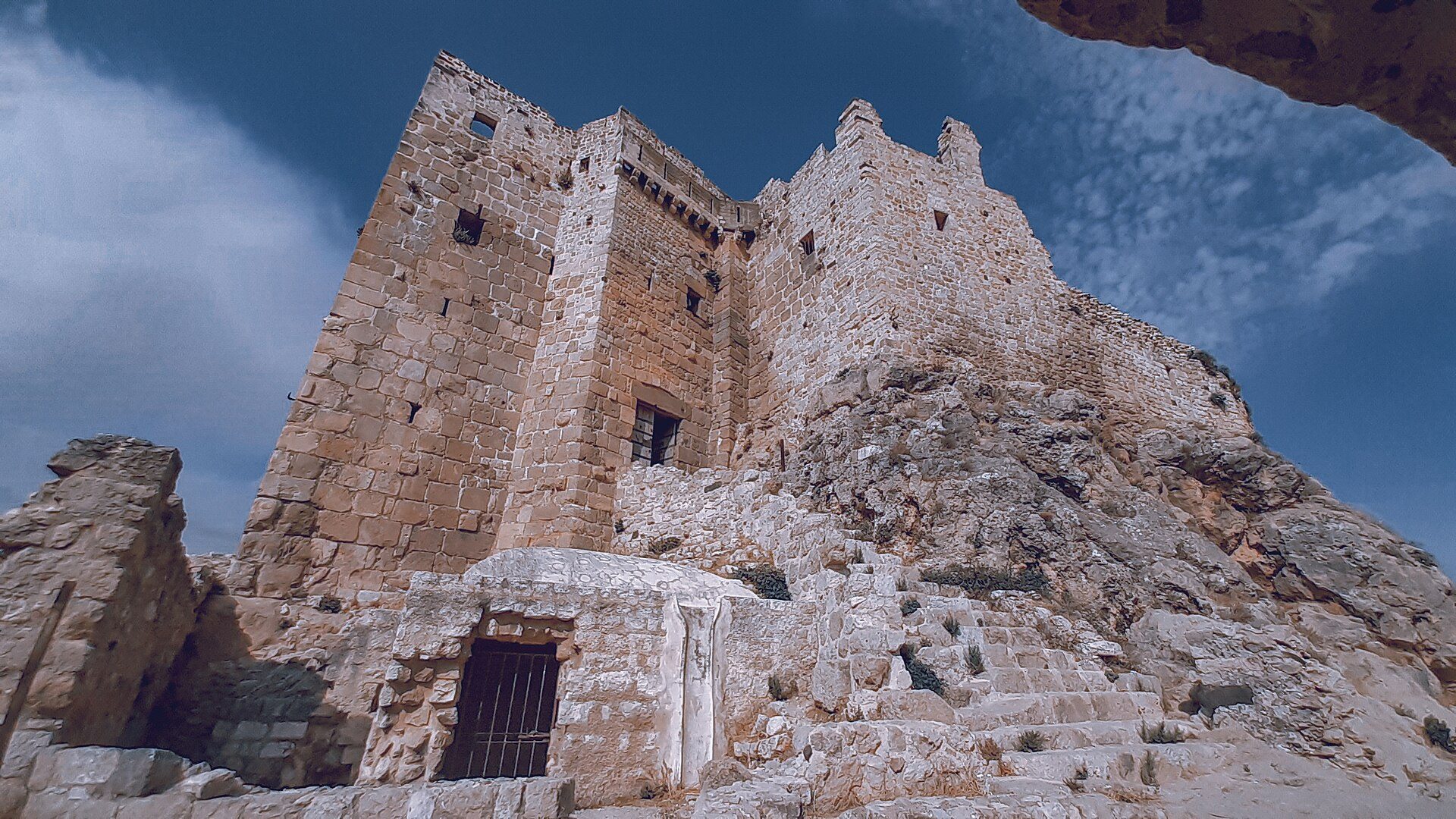 The medieval castle of Masyaf on its rock against the green coastal mountains, in colour