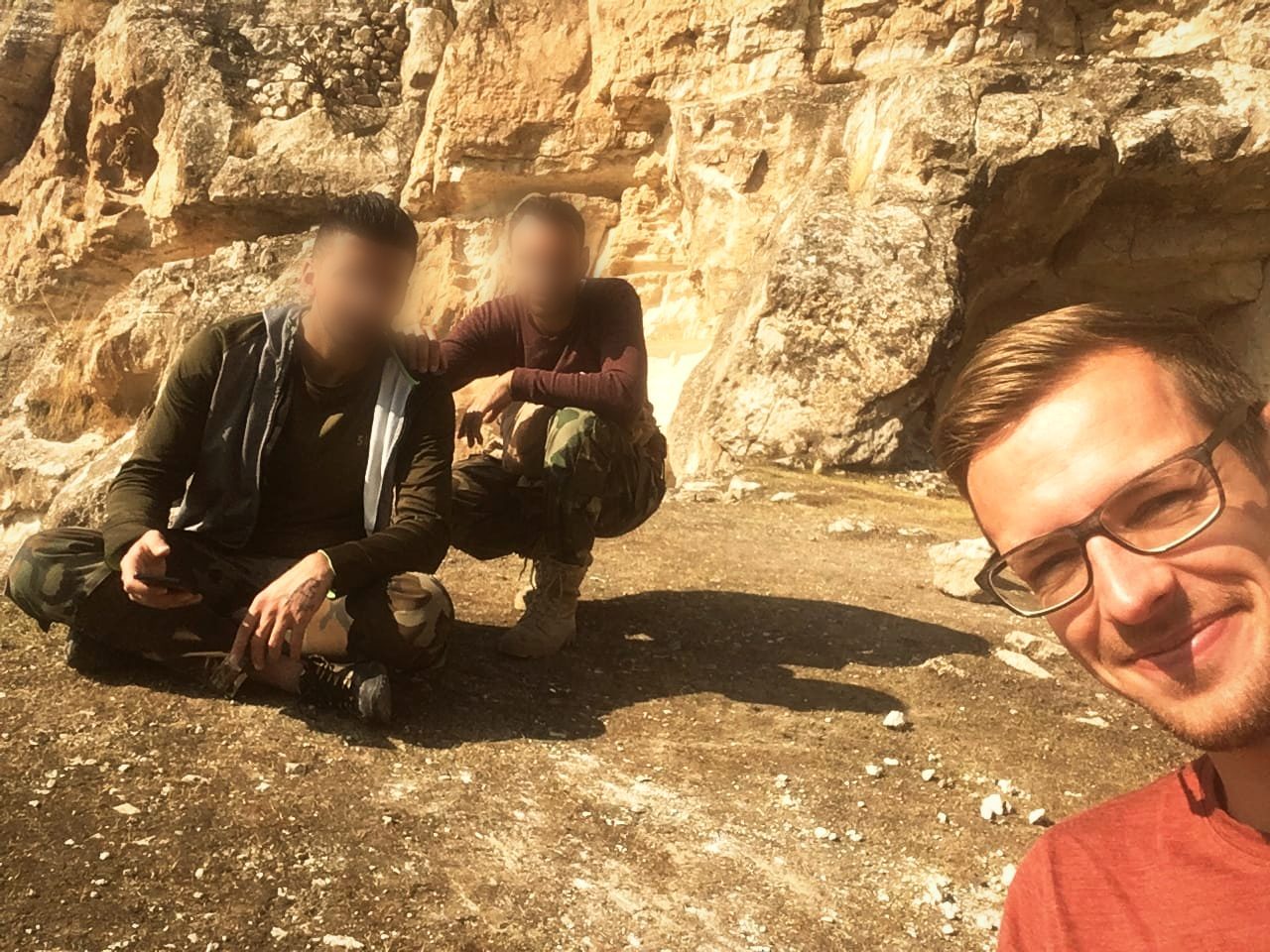 The author with Sargon and Odisho crouching below the cliff at Rabban Hormizd monastery