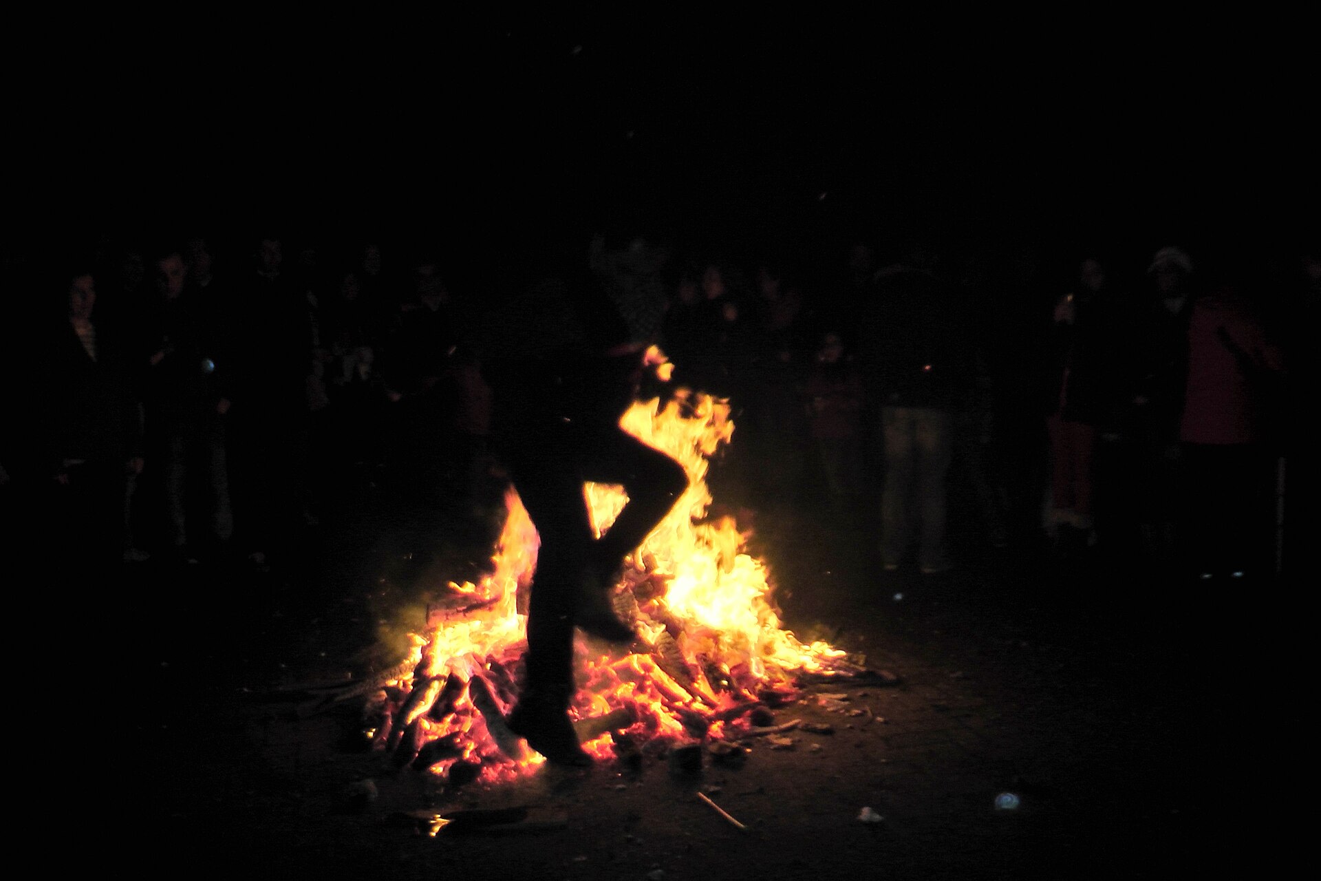 A young man leaps over a street bonfire at the Chaharshanbe Suri festival