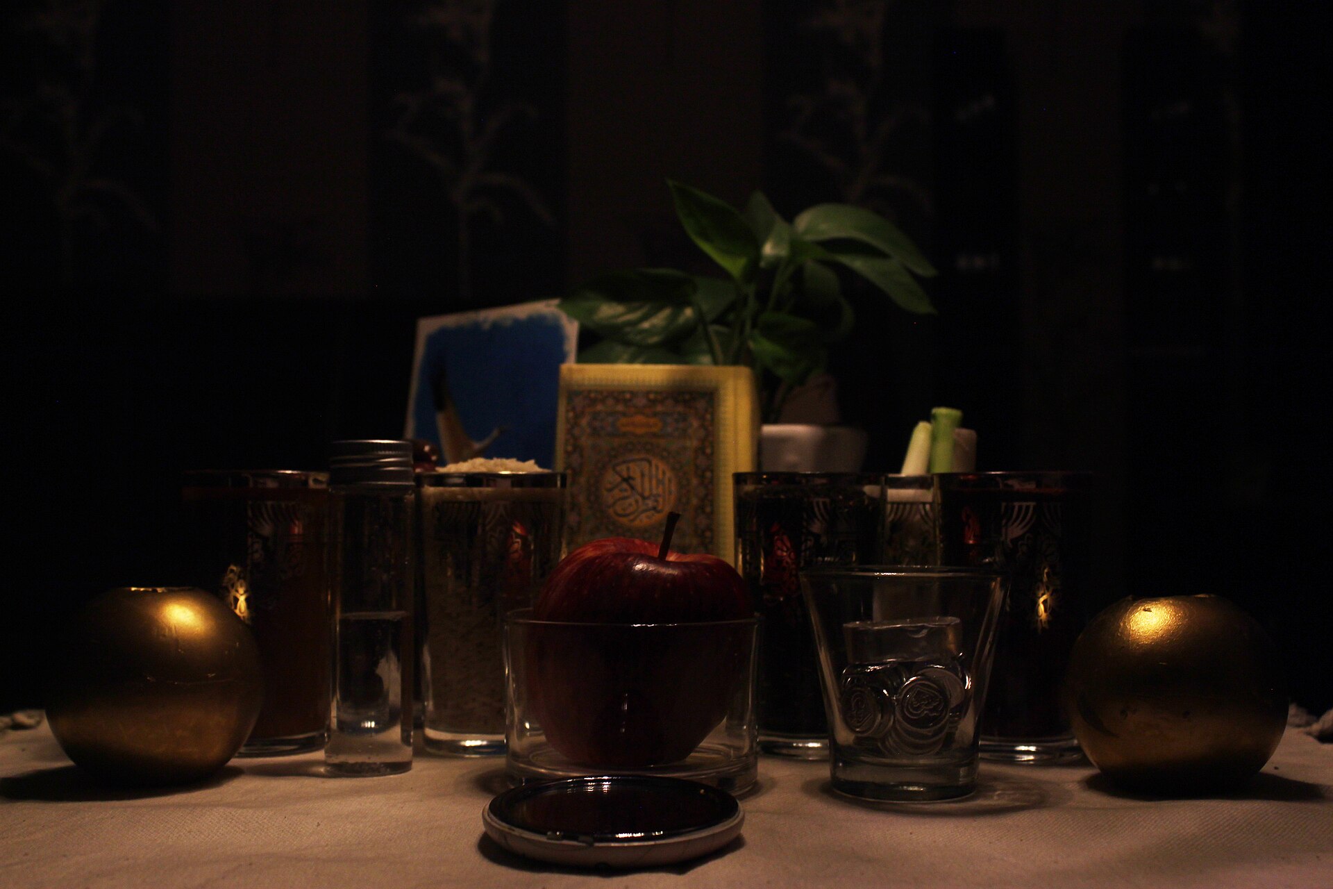 A haft-sin table laid with sprouts, painted eggs, candles, goldfish and a mirror