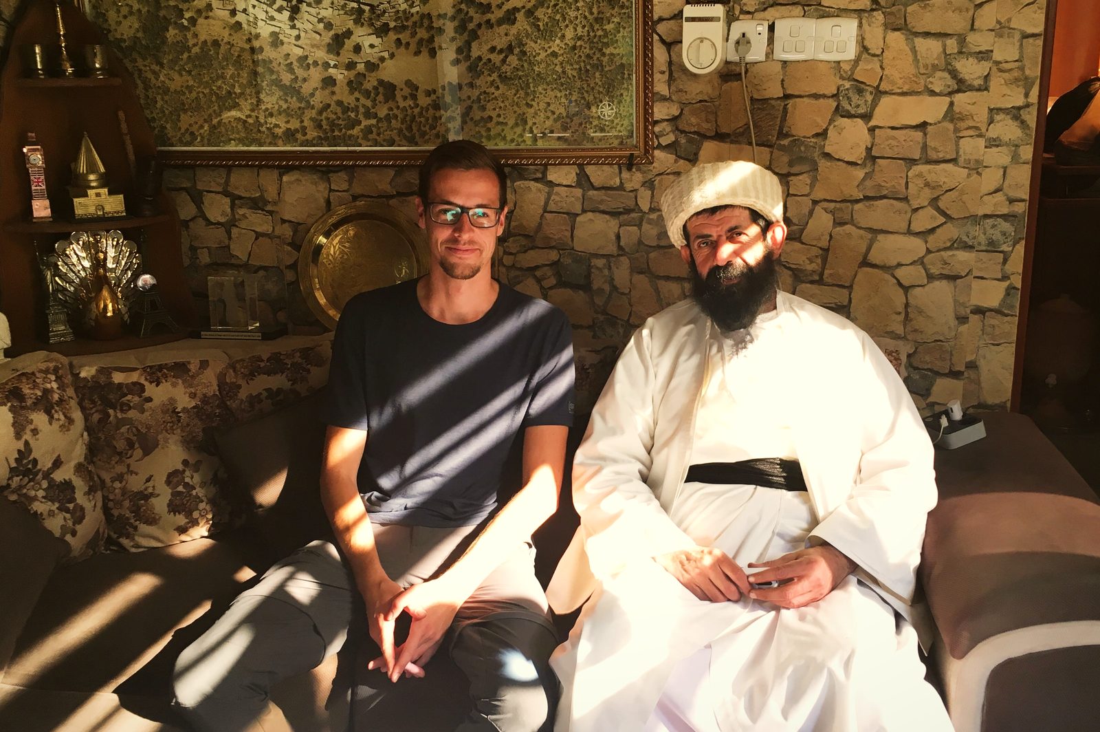 The author seated beside Baba Chawish, custodian of Lalish, who wears white robes and a white cap
