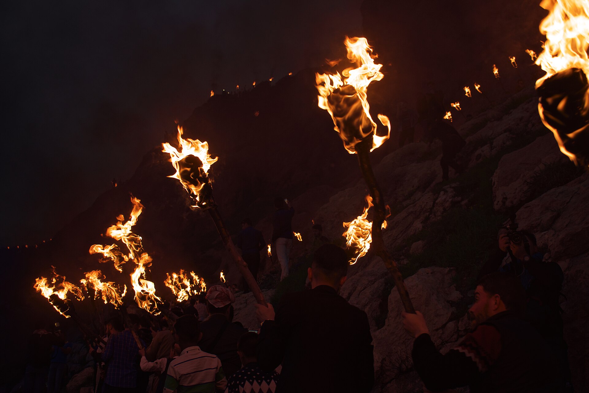 Torch-bearers climbing a hillside in streams of fire at the Newroz festival in Akre, Iraqi Kurdistan