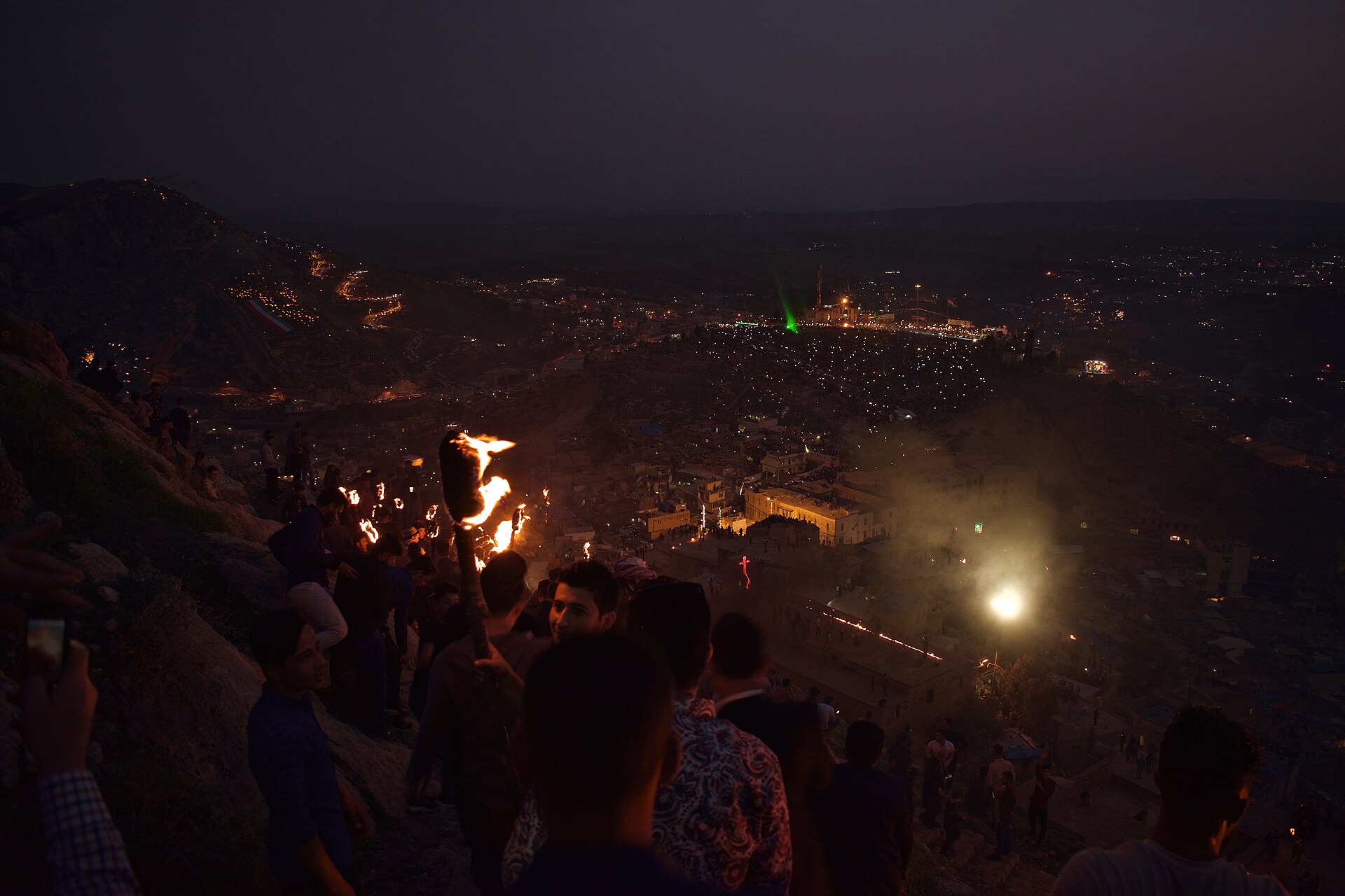 Crowds with flags and torches ascending the hill above Akre at the Newroz fire walk