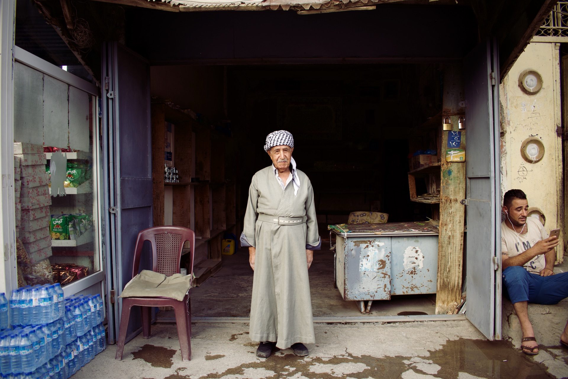 A man in traditional Turkoman dress standing in a shop doorway in Altun Kupri, between Erbil and Kirkuk
