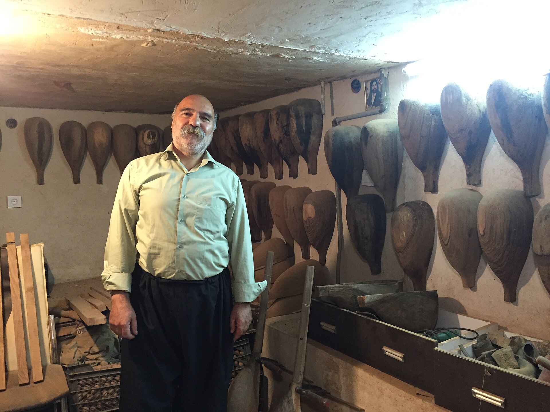 A craftsman in his workshop surrounded by partly finished tanbur lutes